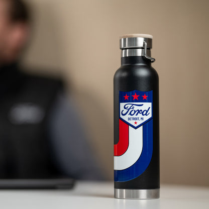 Black water bottle with Ford logo on a blurred background