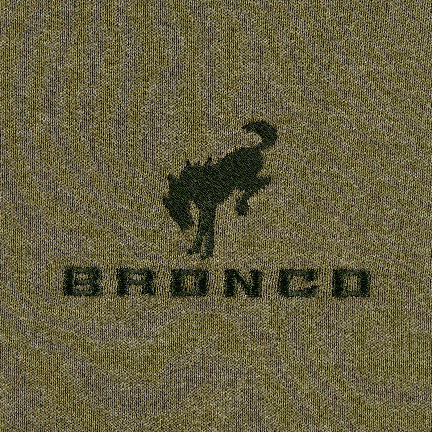 Close-up of a green fabric with a black 'Bronco' logo on a textured background