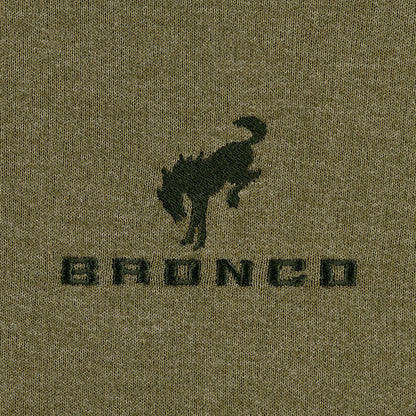 Close-up of a green fabric with a black 'Bronco' logo on a textured background