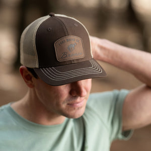 Man wearing a brown and beige cap with a Ford Bronco logo, looking away from the camera.