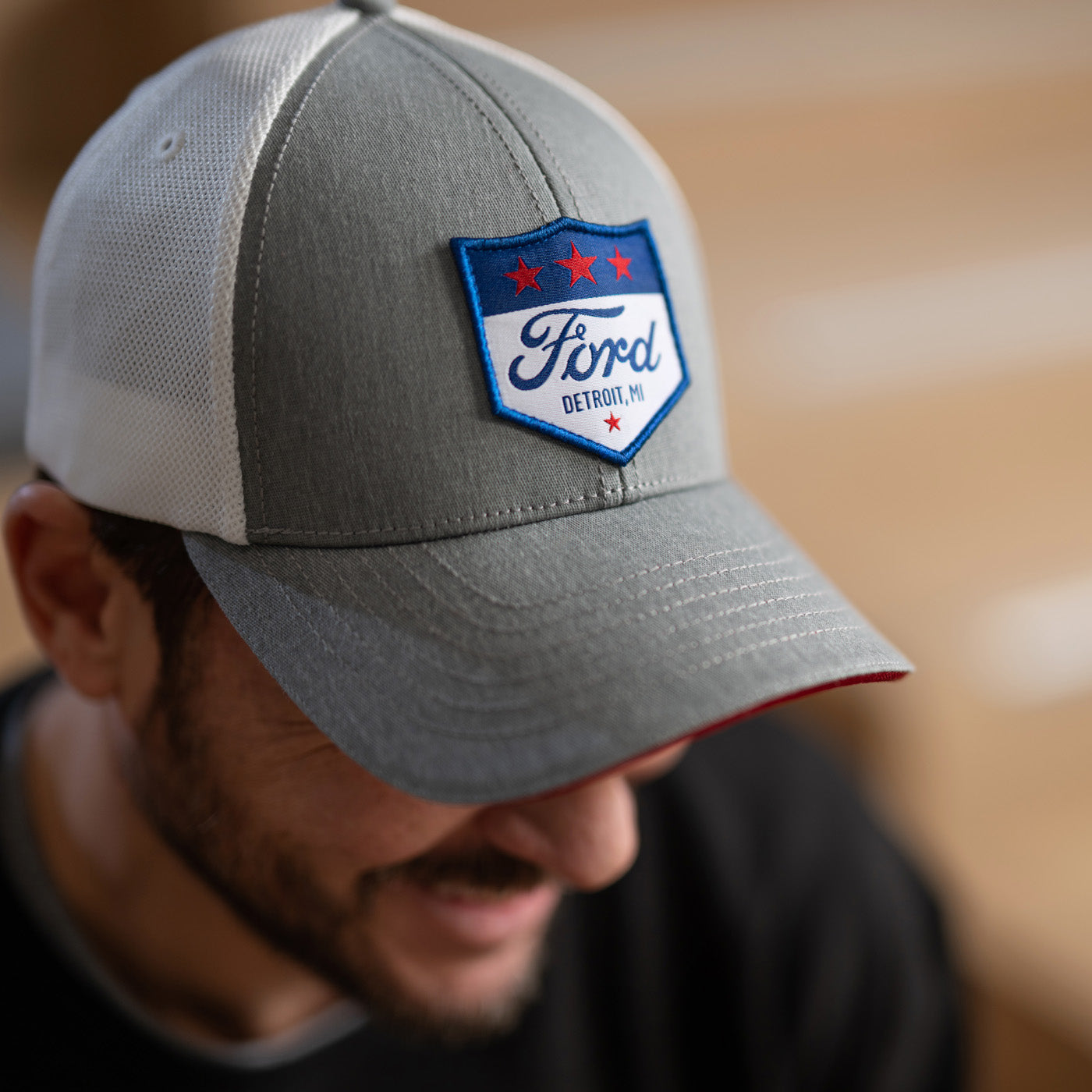 Gray cap with Ford logo hat worn by a person, blurred background