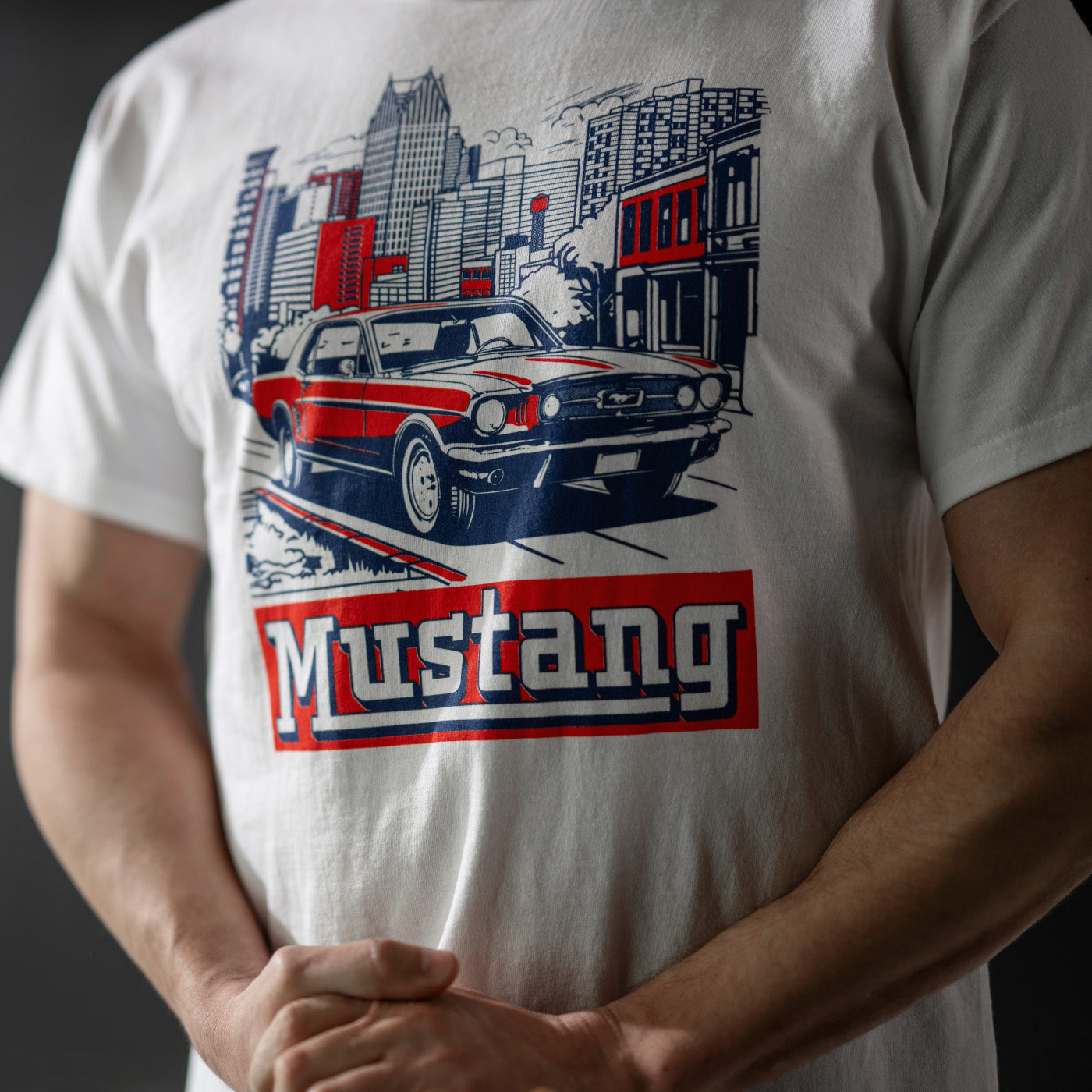 White t-shirt with a graphic of a red and blue car and 'Mustang' text on a dark background