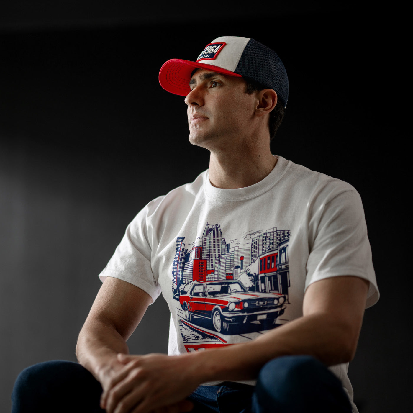 Man wearing a cap and Mustang t-shirt with a graphic design on a dark background