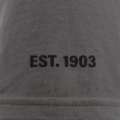 EST 1903 text on a gray background