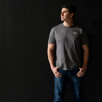 Man wearing a gray t-shirt with a Mustang logo on a black background