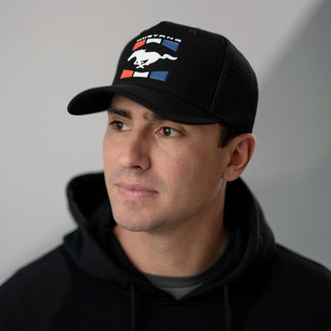 Man wearing a black Mustang cap with a logo on a gray background