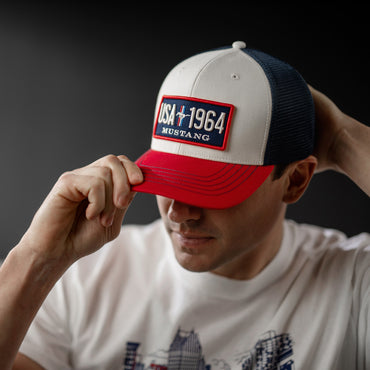 Person wearing a cap with 'USA 1964 Mustang' logo on a dark background