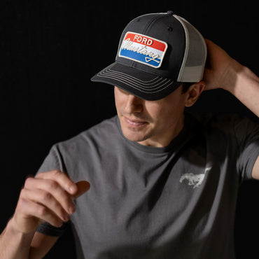 Man wearing a Ford cap and t-shirt with a logo on a black background