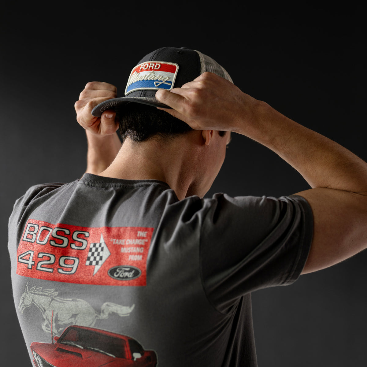 Person wearing a cap and t-shirt with Ford Boss 429 graphics on a dark background