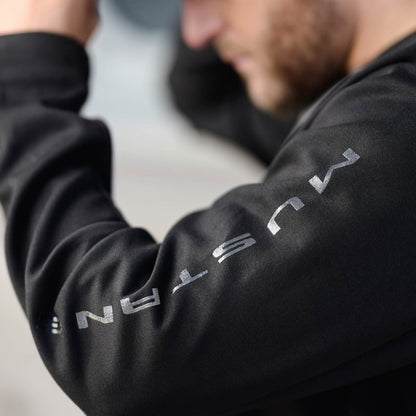 man with left arm up showing mustang text down the sleeve of a black sweatshirt