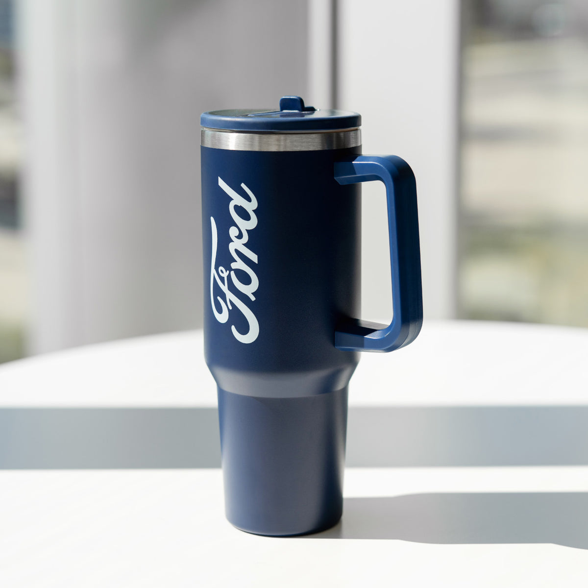 navy blue tumbler with ford script sitting on a table
