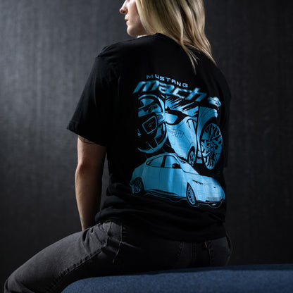 woman wearing a mustang mach-e t-shirt sitting on a bench on a black background