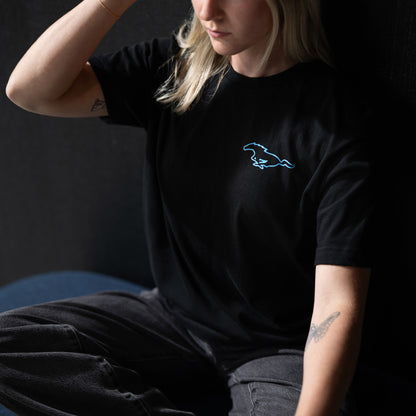 woman wearing a mustang mach-e t-shirt sitting on a bench on a black background