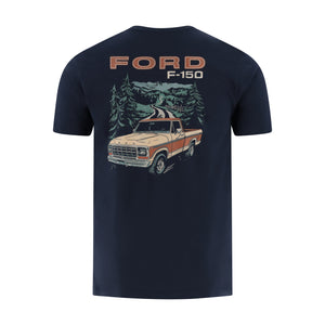 A navy blue short-sleeve t-shirt with a large graphic print on the back featuring a vintage Ford F-150 truck, pine trees, mountains, and 'FORD F-150' text.