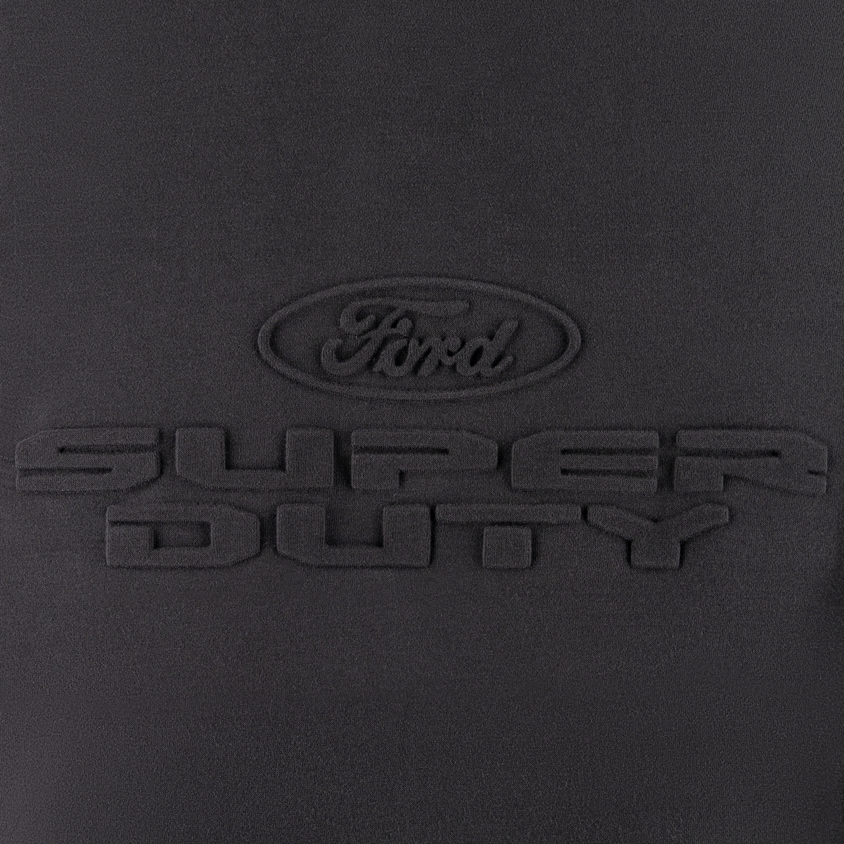 close up of embossed ford oval logo and super duty text on a black background