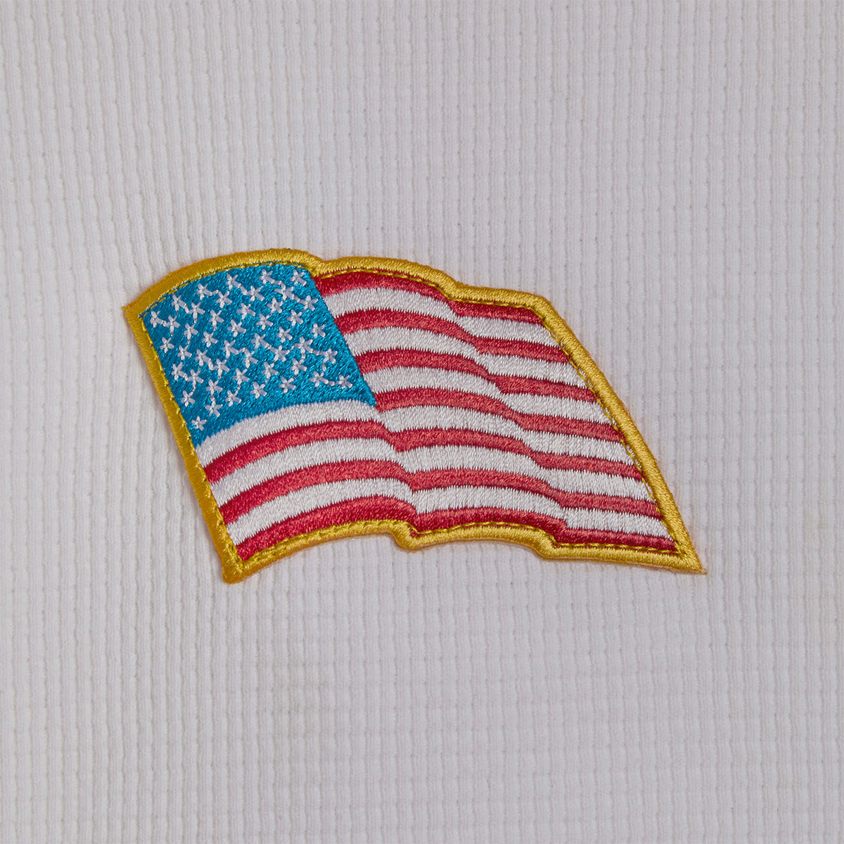 close up of an embroidered american flag on a waffle knit background