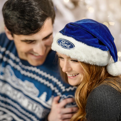 Person wearing a blue Ford logo Santa hat with a blurred background
