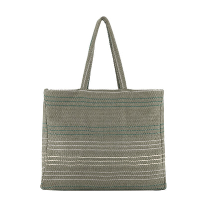 A woven tote bag in a muted sage green color, featuring thin horizontal stripes in white and teal, with two top handles, shown against a plain white background.
