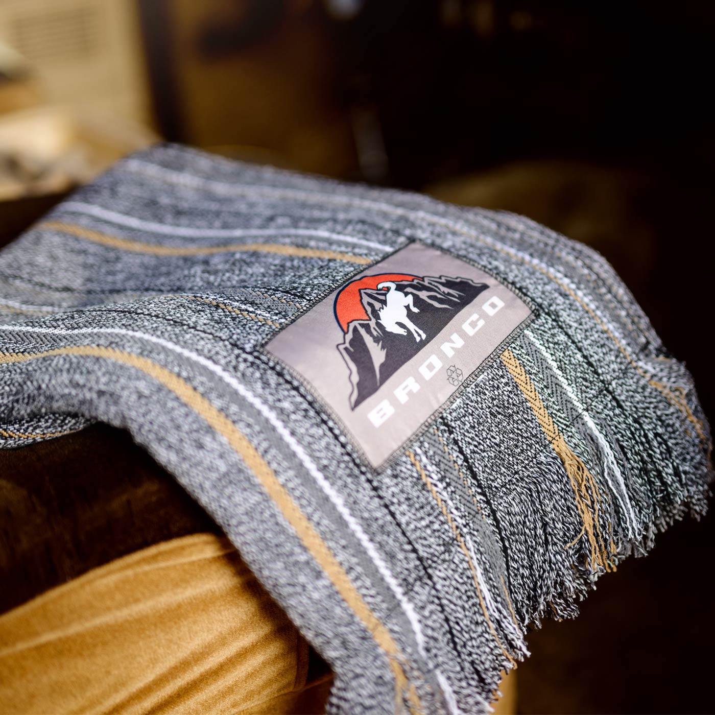 Close-up of a denim fabric with a 'Bronco' brand label on a wooden surface.