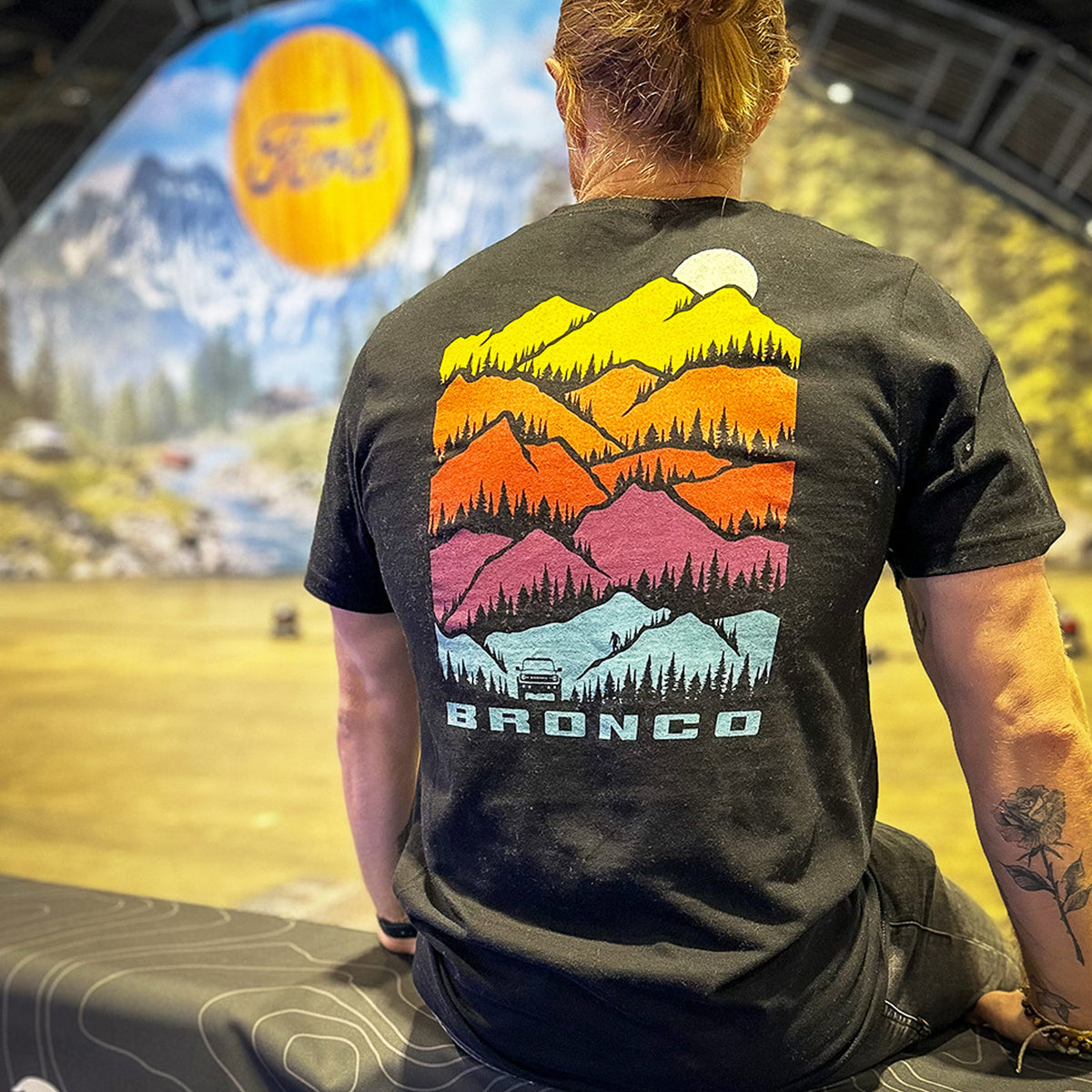man wearing a mountain graphic bronco t-shirt