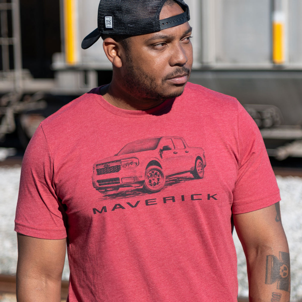 man wearing a black hat wearing a red Ford Maverick graphic t-shirt