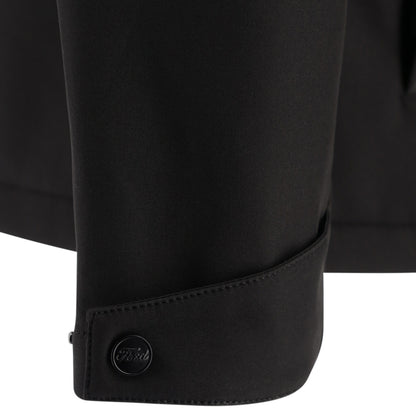 Close-up of a black jacket with a button on a white background