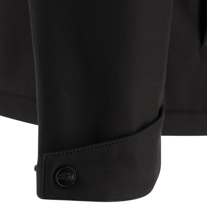 Close-up of a black jacket with a button on a white background