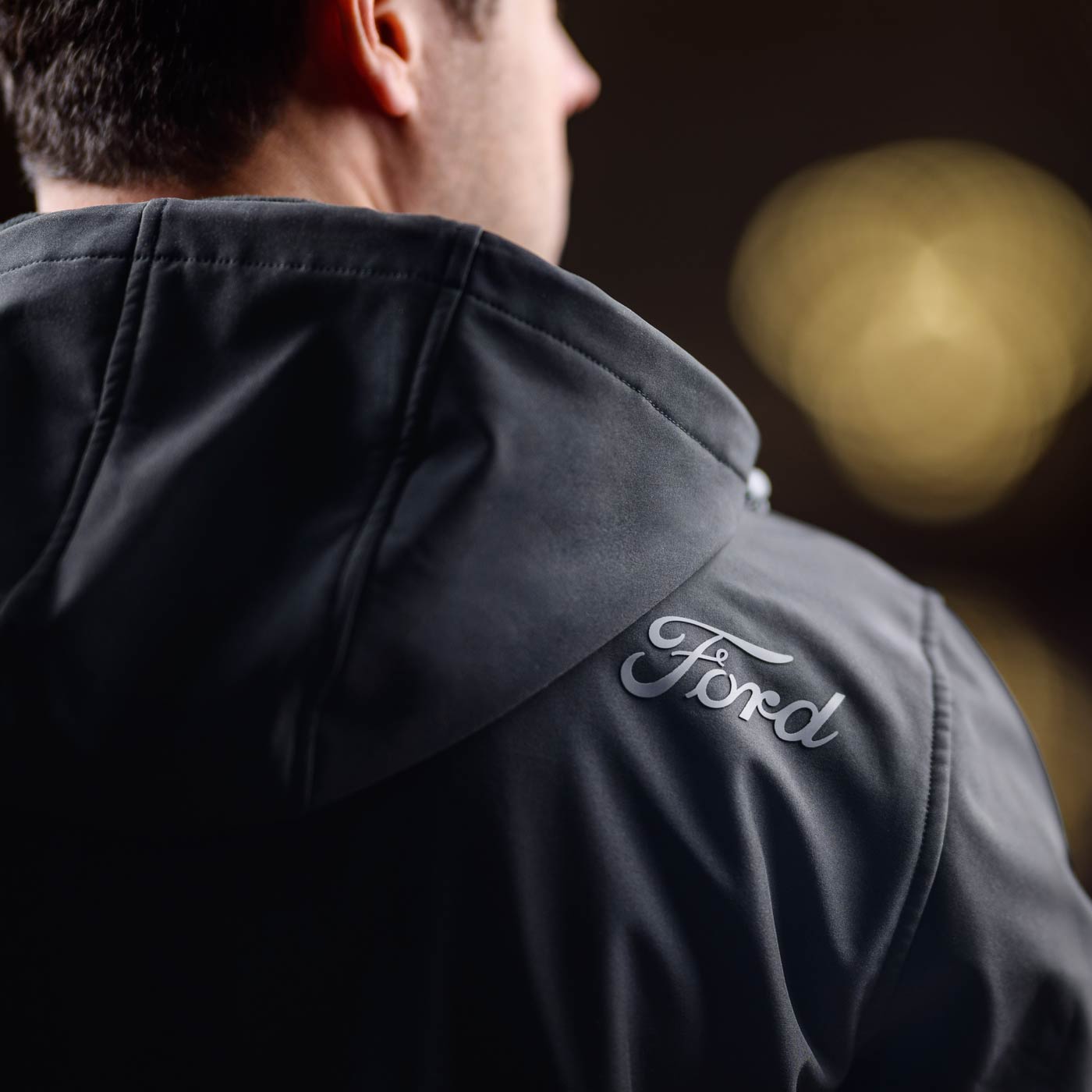 Black jacket with Ford logo on the back, blurred background