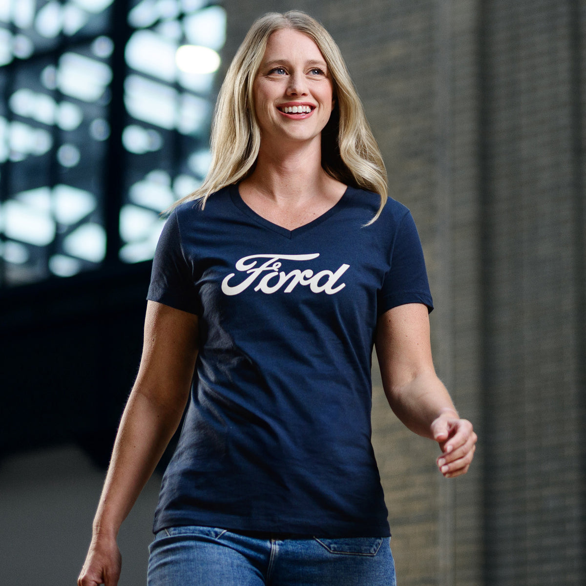 Woman wearing a navy blue 'Ford' t-shirt standing indoors.