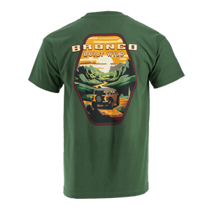 A green short-sleeved T-shirt with a graphic print on the back showing a vintage design with a Ford Bronco vehicle in a outdoor setting.