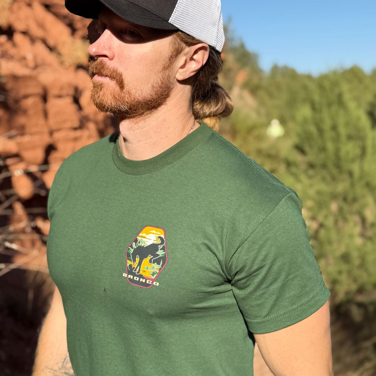 man in the desert wearing a green ford bronco t-shirt