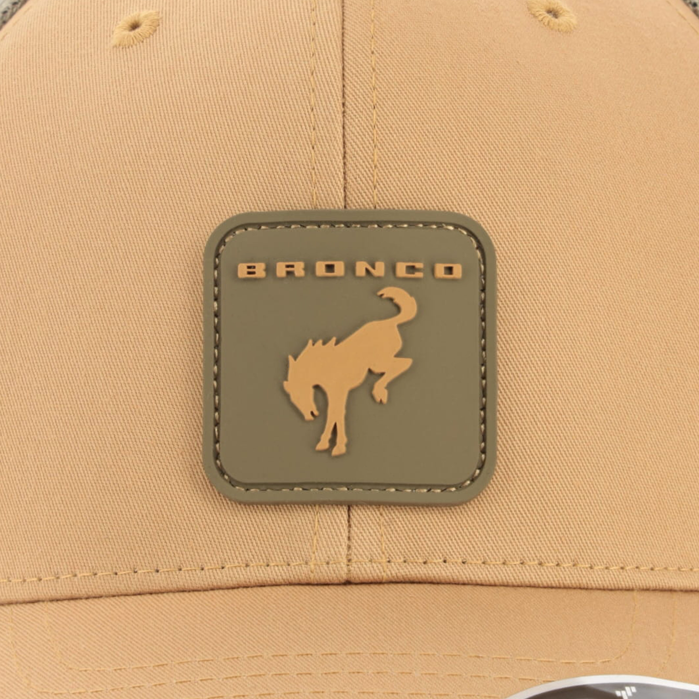 Beige cap with a bronco logo patch on a beige background