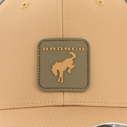 Beige cap with a bronco logo patch on a beige background