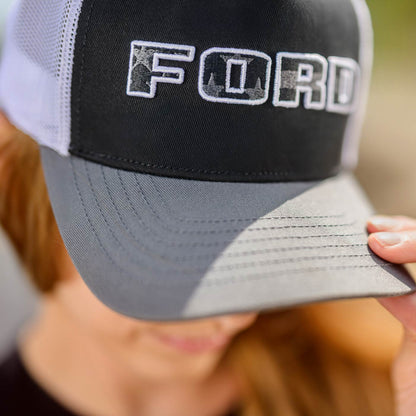 Trucker hat with 'FORD' logo held by a person