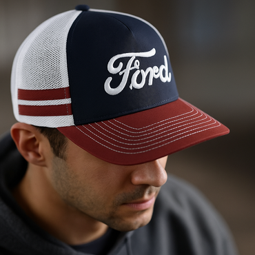 Person wearing a Ford-branded red white and blue cap with a blurred background
