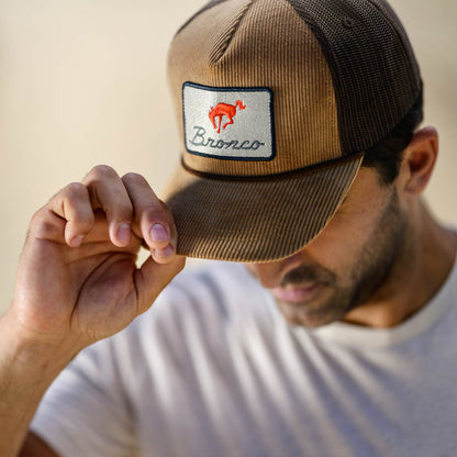 man tipping corduroy bronco hat with bronco patch