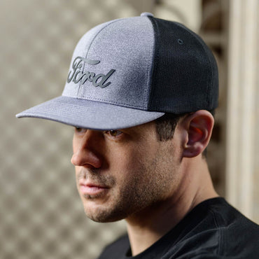 Man wearing a gray and black cap with 'Ford' logo, blurred background