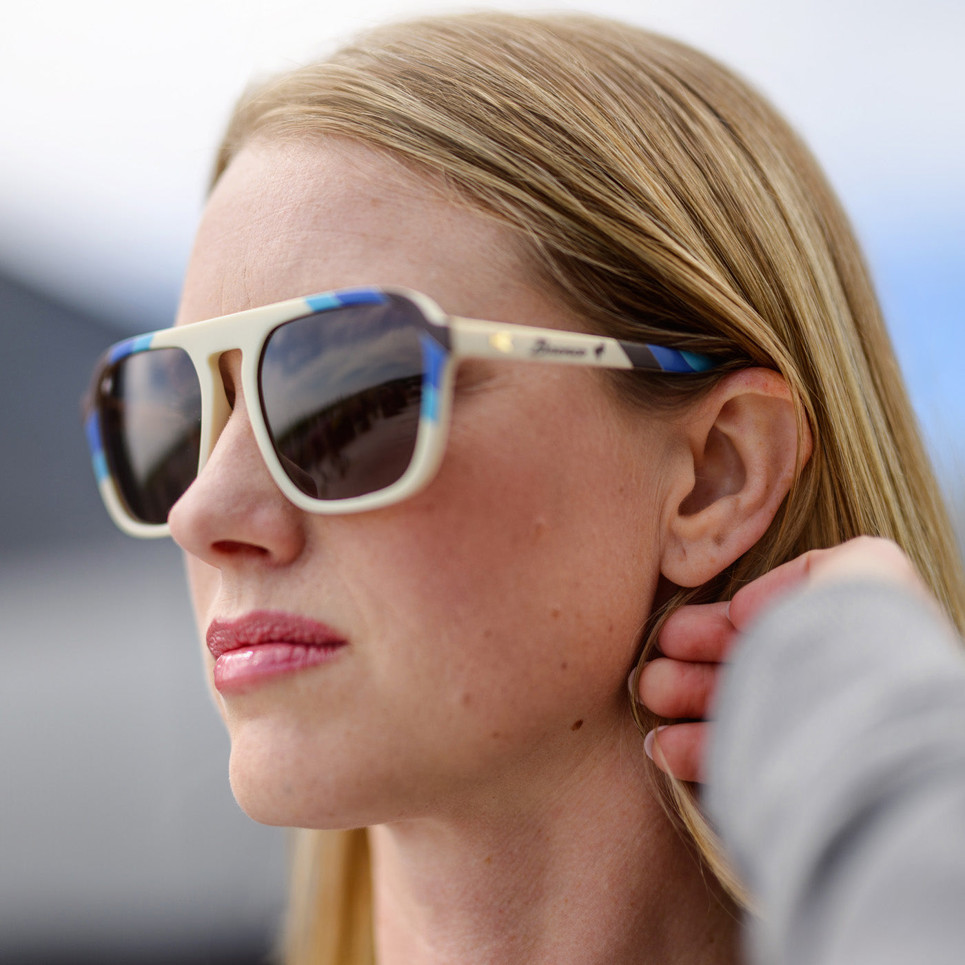 Close-up of a person wearing sunglasses with a blurred background