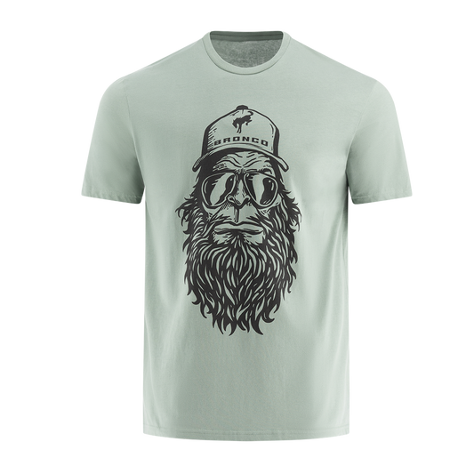 Men's T-shirt with a graphic print of a bearded Sasquatch wearing sunglasses and a hat, in a light color.