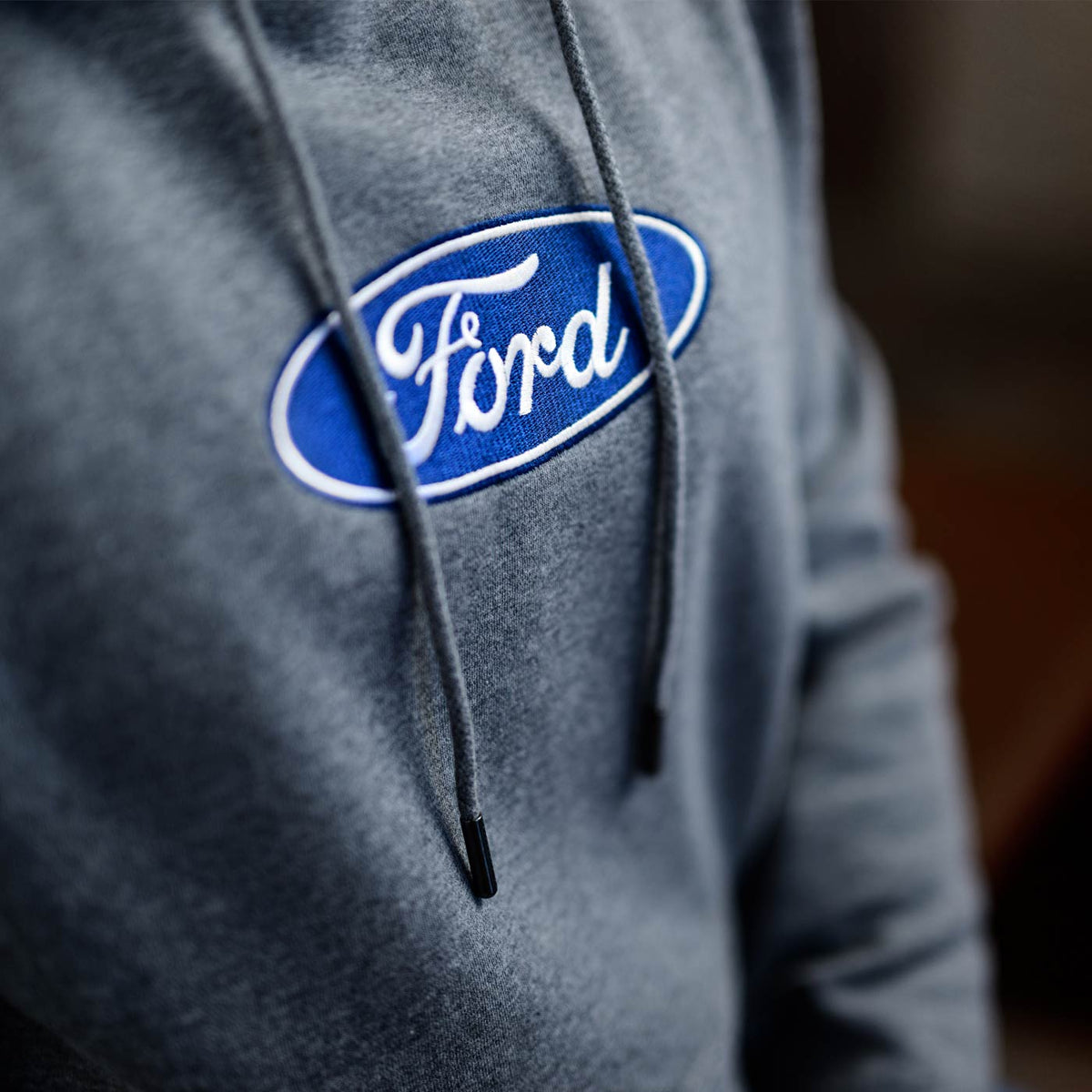 Gray hoodie with Ford logo on a blurred background