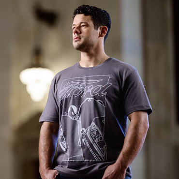 Man wearing a gray t-shirt with a Ford logo and design.