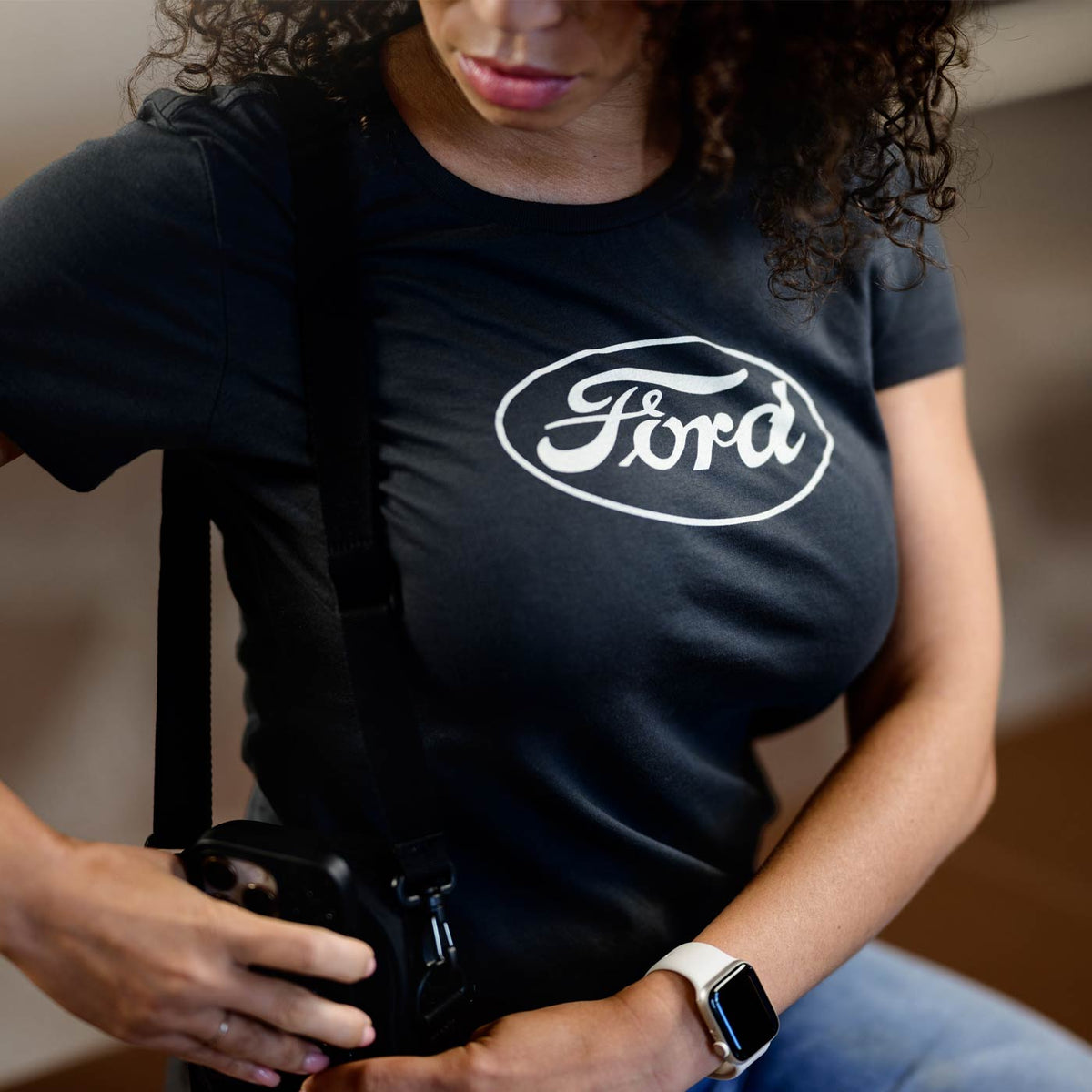 Person wearing a black Ford t-shirt holding a camera.