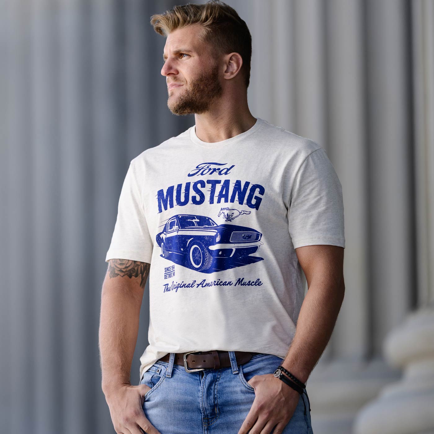 Man wearing a white t-shirt with Ford vintage Mustang graphic design.