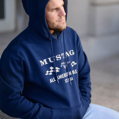 Man wearing a blue hoodie with 'Mustang' branding in an indoor setting