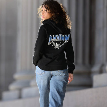 Person wearing a black hoodie with 'Mustang' logo in an outdoor setting