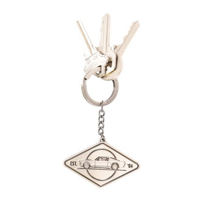 Silver keychain with a car emblem on a white background