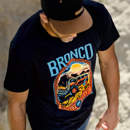 Person wearing a black t-shirt with 'Bronco' graphic design.