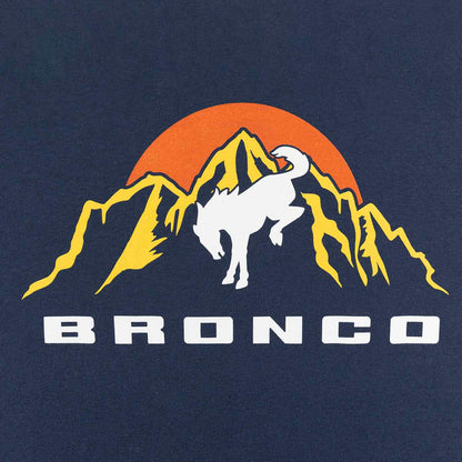 close up of yellow mountain graphic with orange sun and white bronco text on blue background