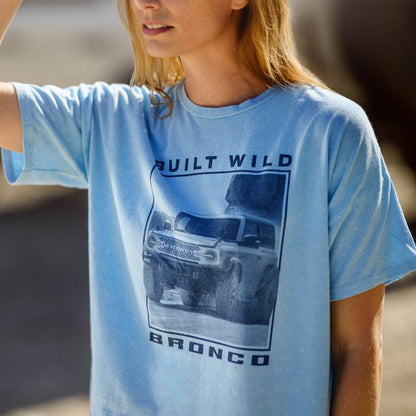 Person wearing a blue t-shirt with a graphic design and text.