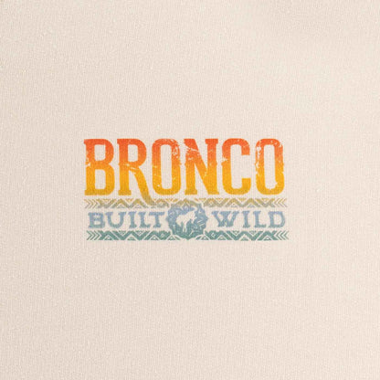 close up of multicolor ombre bronco built wild text on cream background